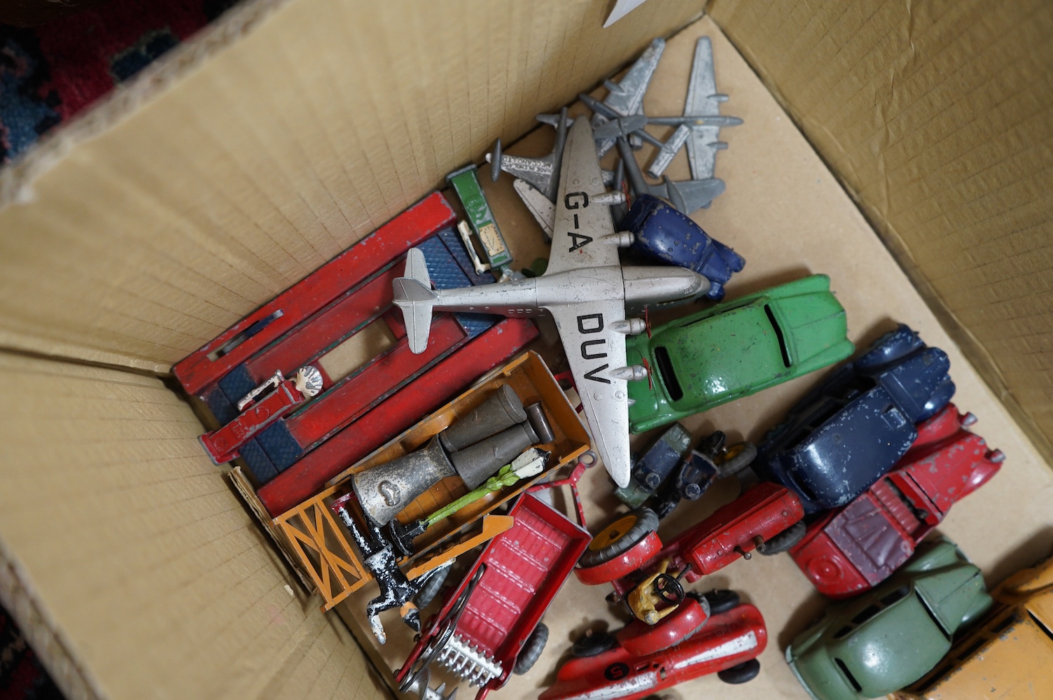 Twenty-five Dinky Toys, mainly late 1940s-50s examples including; a Triumph, Austin Devon, Austin Taxi, Sunbeam Talbot, Ford Sedan, racing cars, farm vehicles, aircraft, etc. together with a box of red and green Meccano.